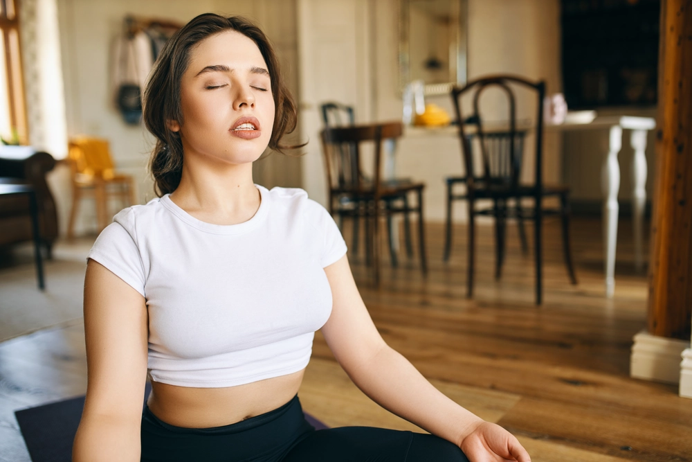 beautiful-young-caucasian-woman-with-muscular-curvy-body-sitting-lotus-posture-home-keeping-eyes-closed-meditating-during-yoga-practive-doing-body-scanning-concentrating-breathing